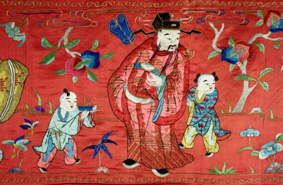 Chinese tapestry or banner, red silk with hand-embroidered figures around the border and one hundred characters hand-embroidered in the center with gold thread. The piece is canvas backed and has canvas loops along the top to allow for hanging.