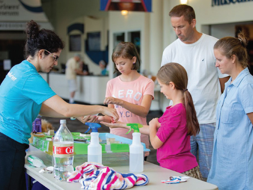 Mariners' Educator showing a family a science experiment.