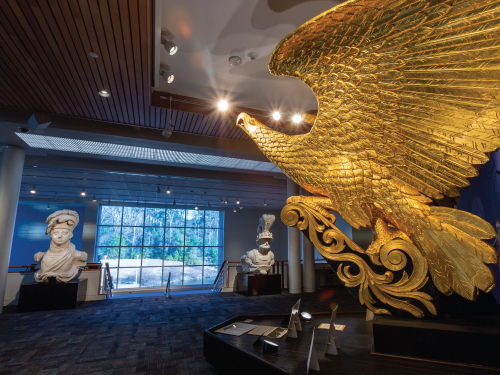 Sweeping view of the Mariners' Main Lobby with the iconic gold USS Lancaster eagle figurehead on the right.