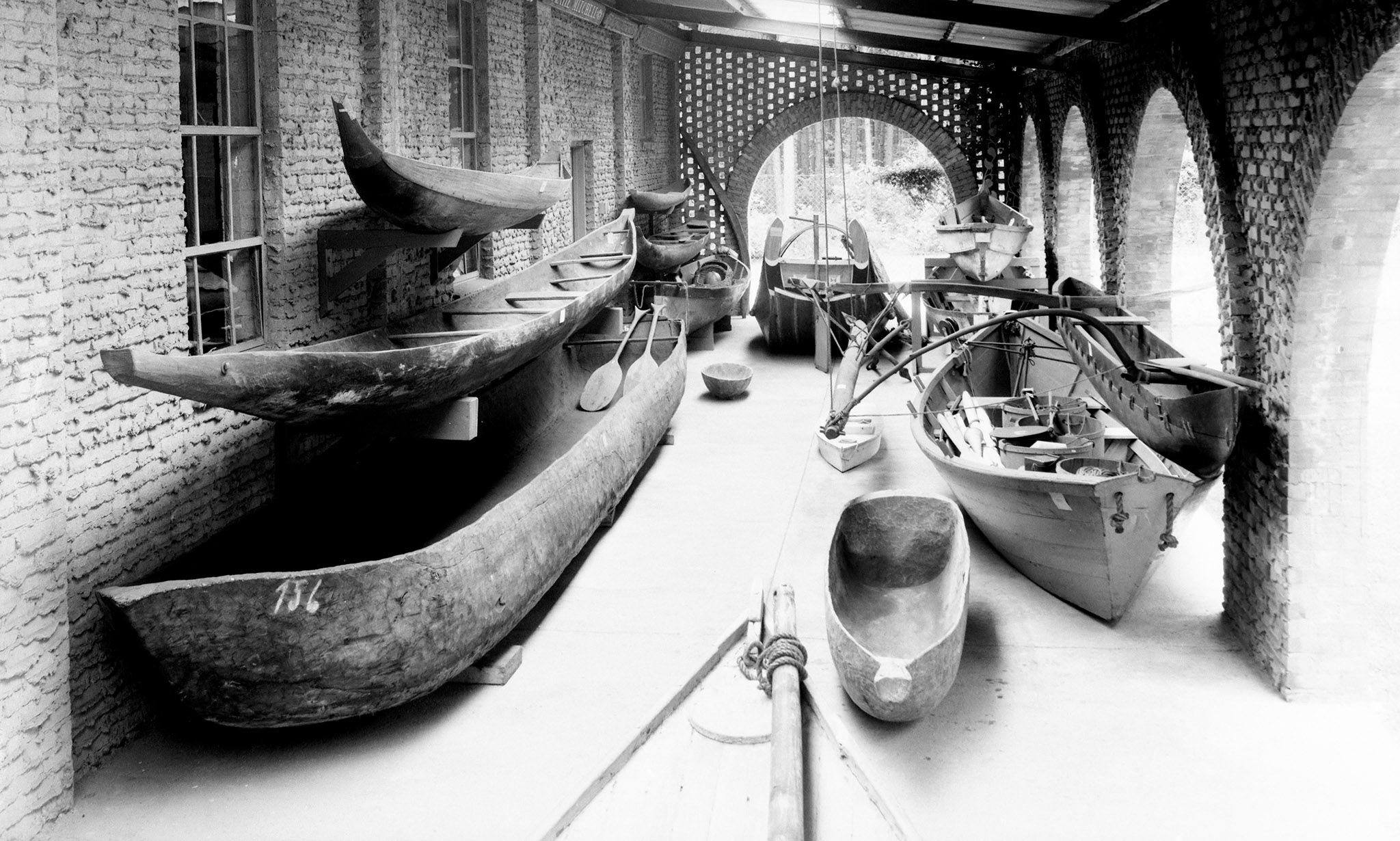 A handful of small boats sitting under the Museum's colonnade in 1938. The image is black and white. 