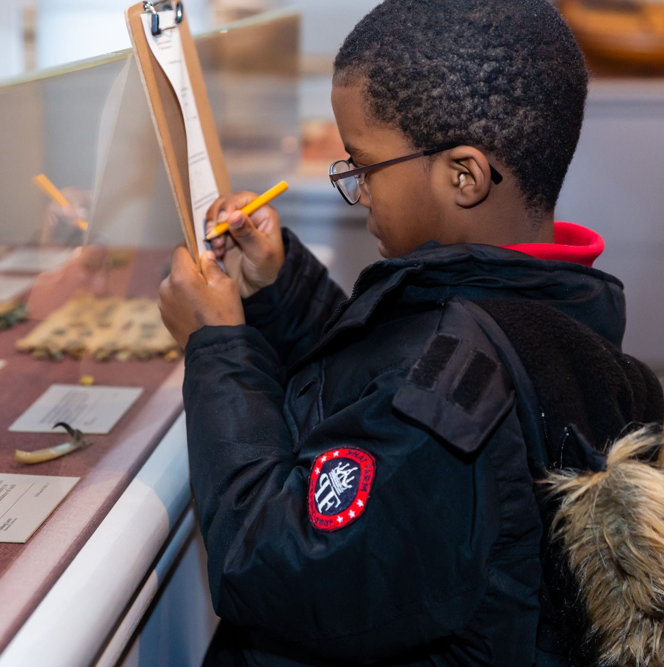 child works on scavenger hunt in museum gallery. 