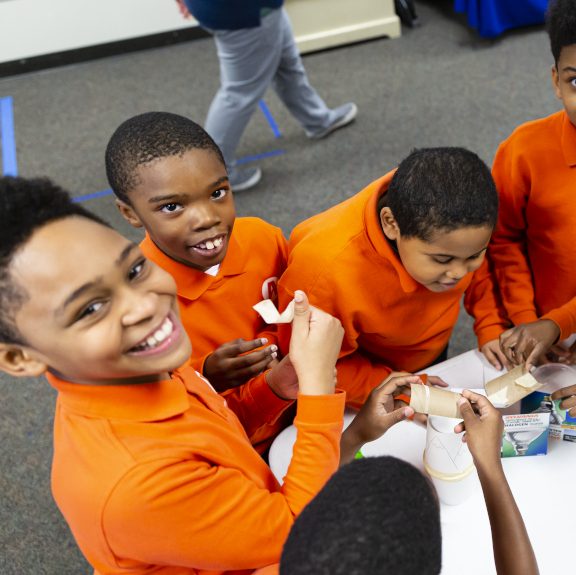 A group of five students participate in a hands-on educational activity.