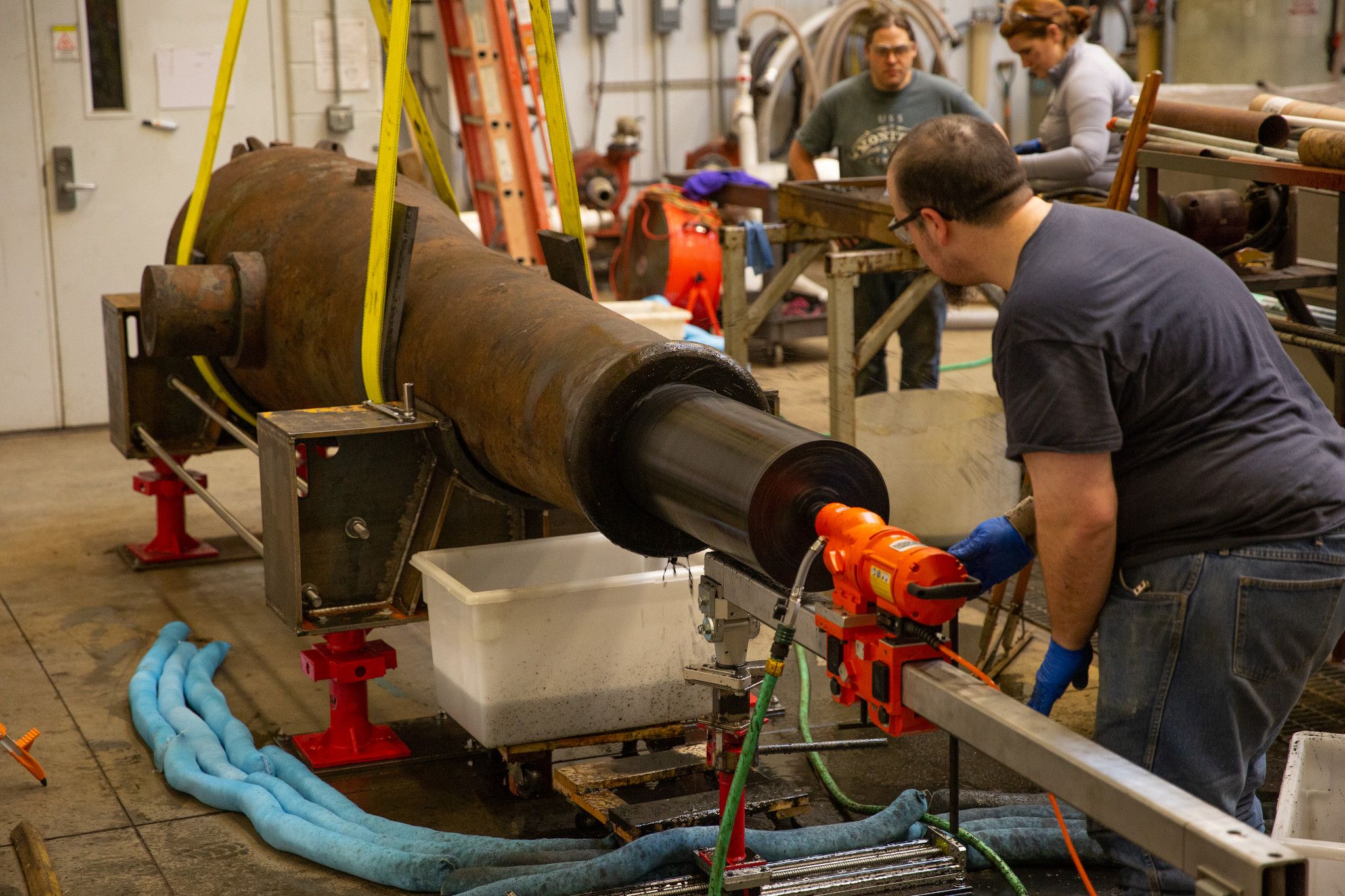 Archaeological Conservator Erik Farrell is using a custom-made drilling bit to bore out one of USS Monitor's Dahlgren guns in the Museum's Wet Lab.