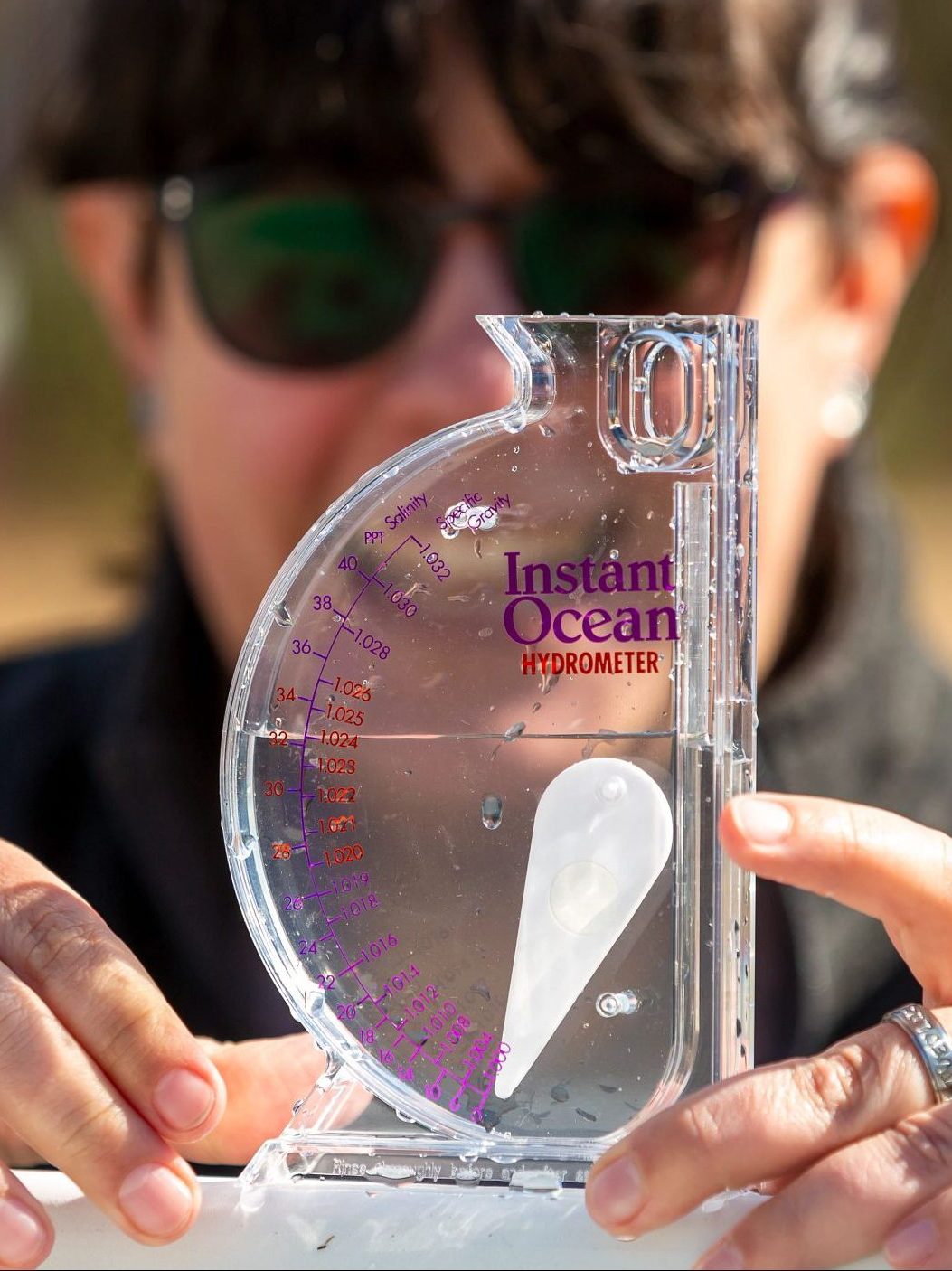 Woman takes reading from a hydrometer.