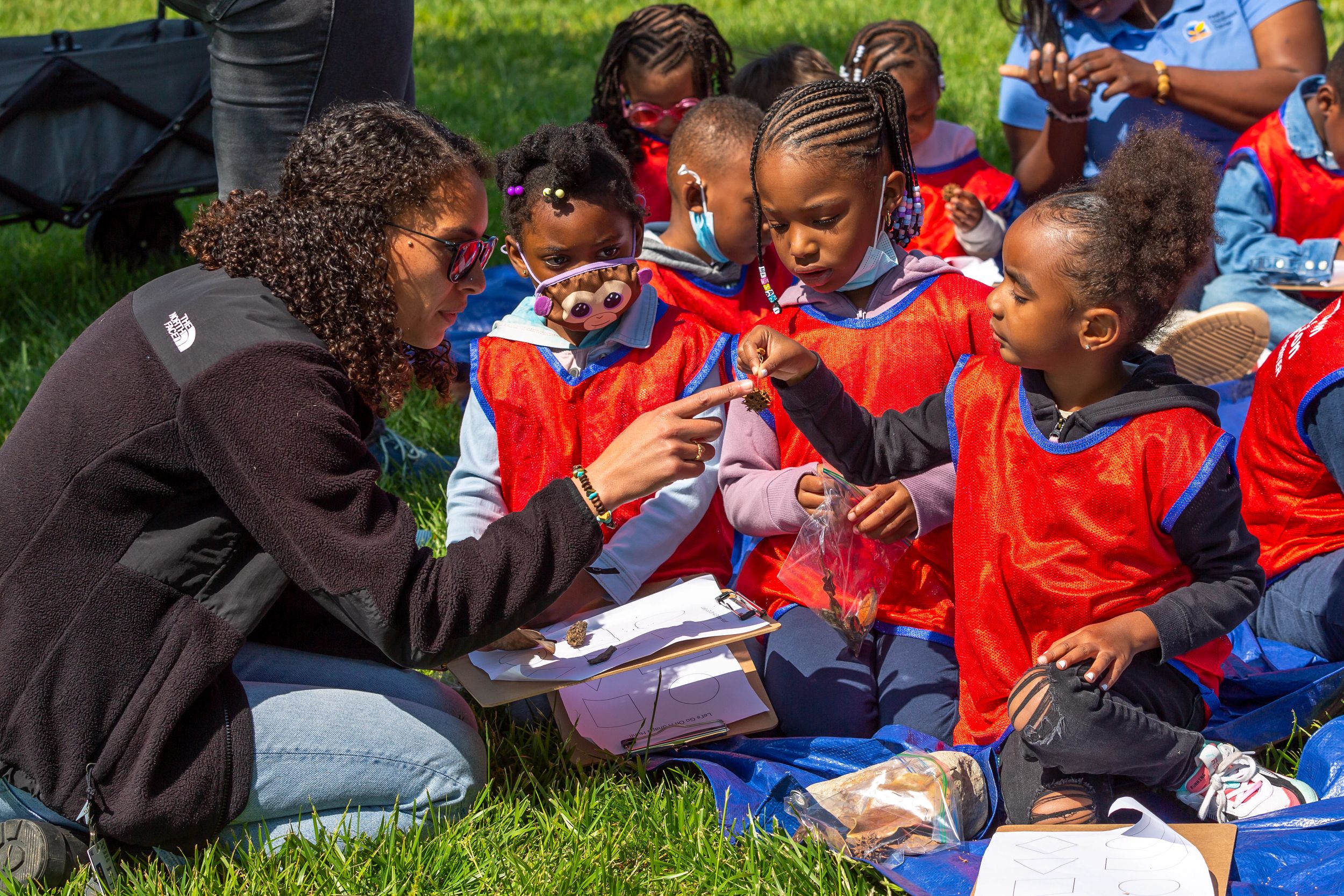 Museum educator takes group of students through an outdoor hands-on activity in Mariners' Park. 