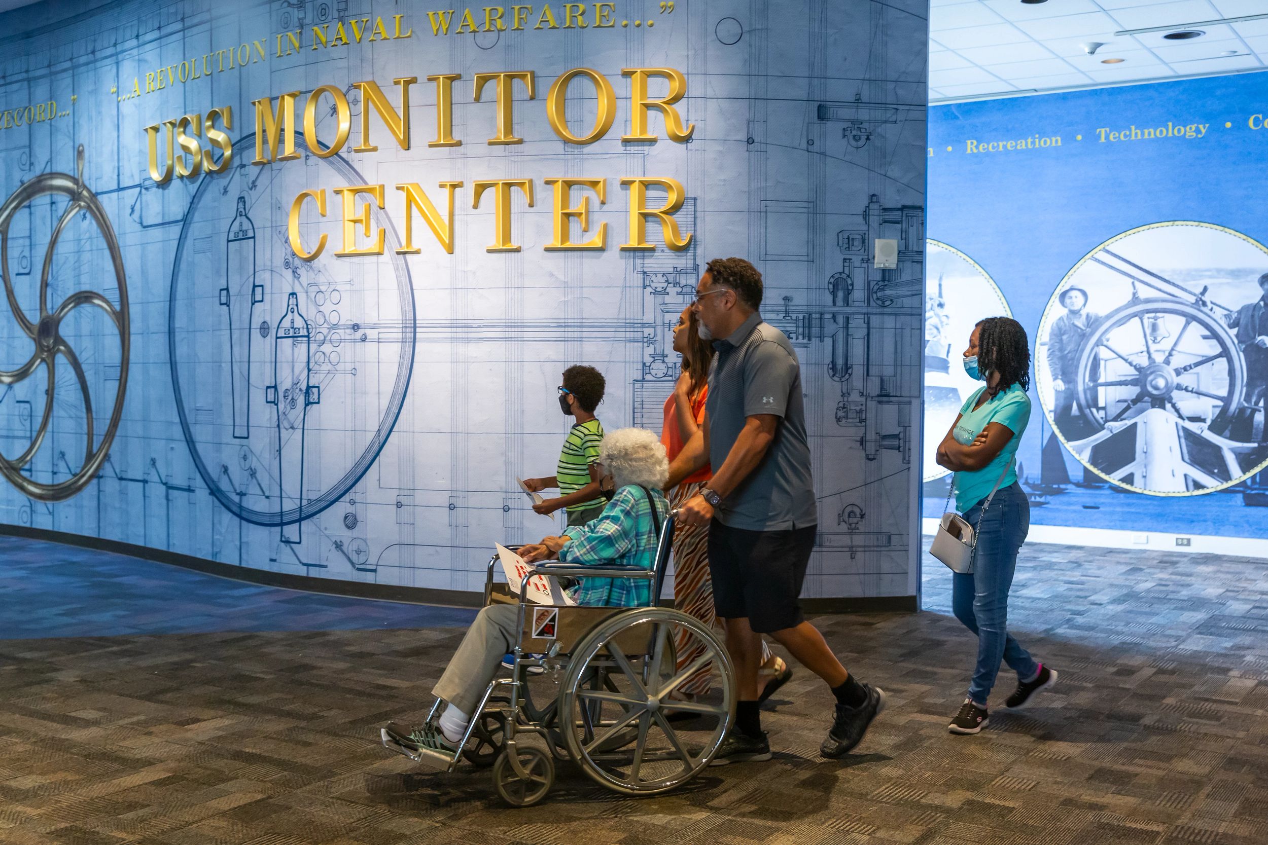 Family walking towards the USS Monitor Center. One guest is in a wheelchair.