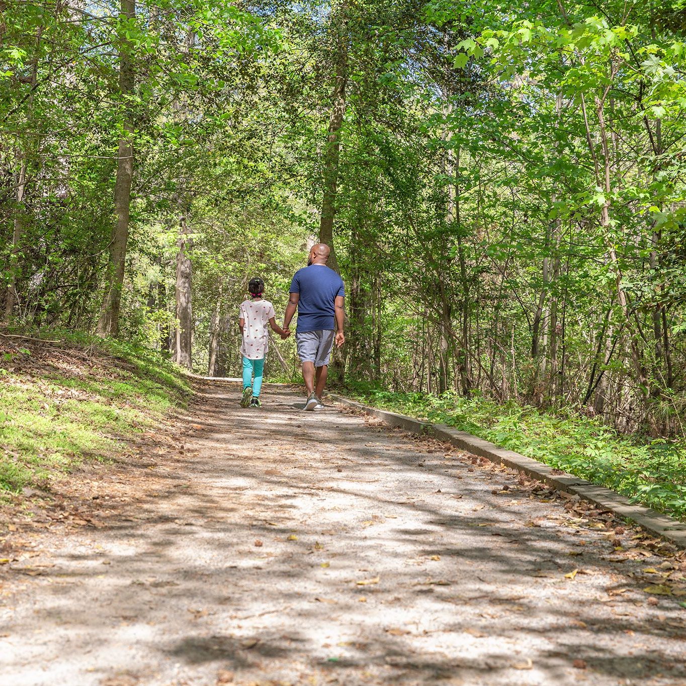 Adult and child walk on the Noland Trail.