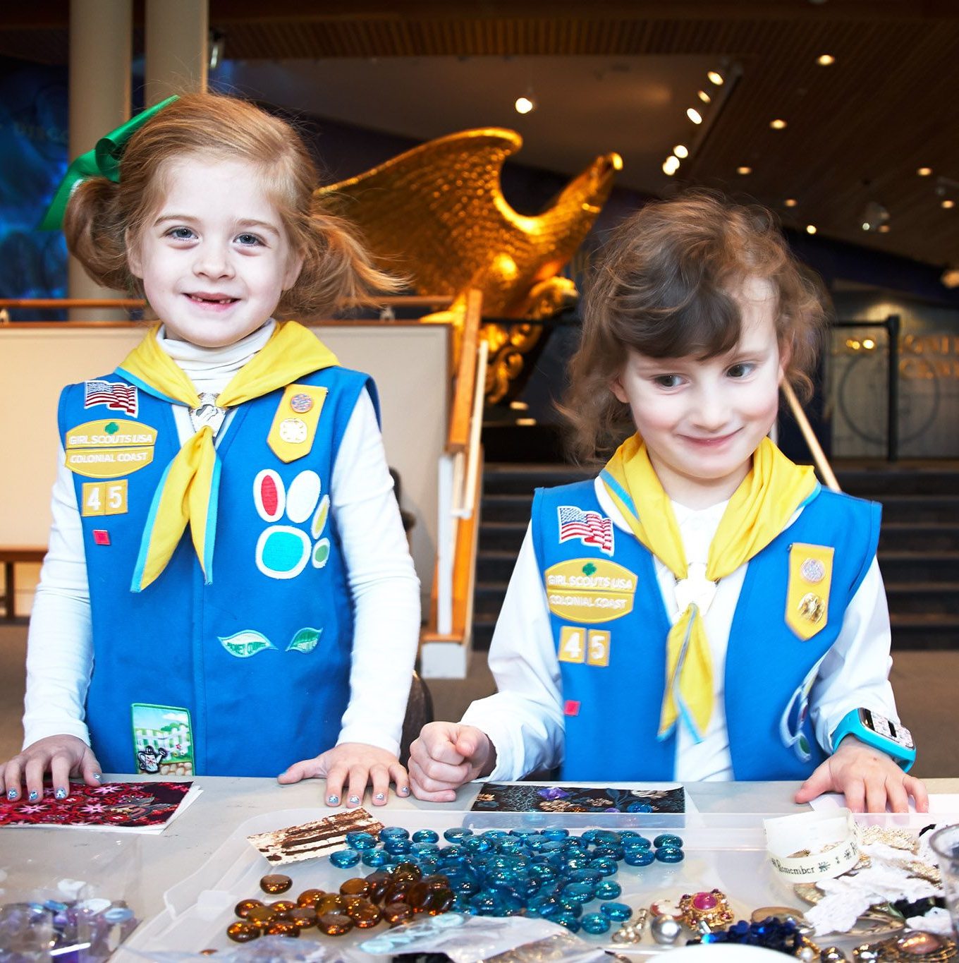 Two girl scouts working on a craft in the Museum's Main Lobby