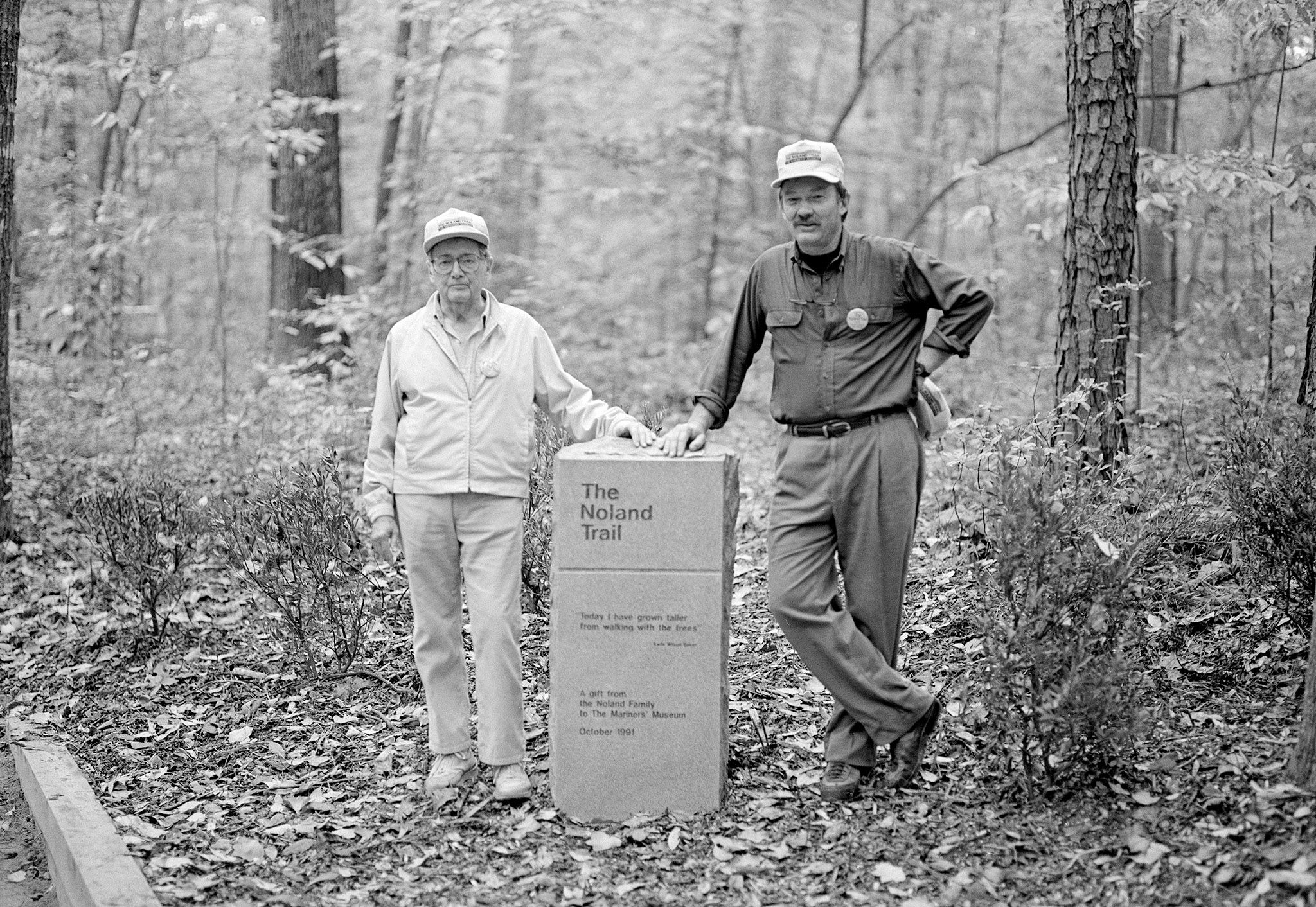 Black and white image of a man and woman standing at the entrance to the Noland Trail. 