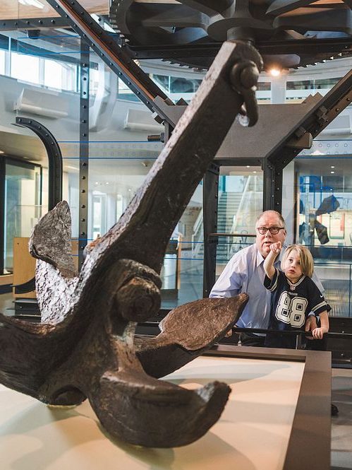 Grandfather and grandson looking at USS Monitor's anchor.