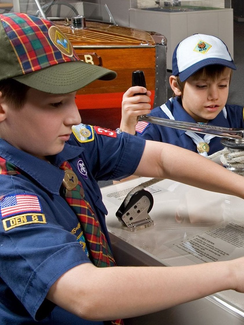 Two boy scouts try hands-on activity in gallery.