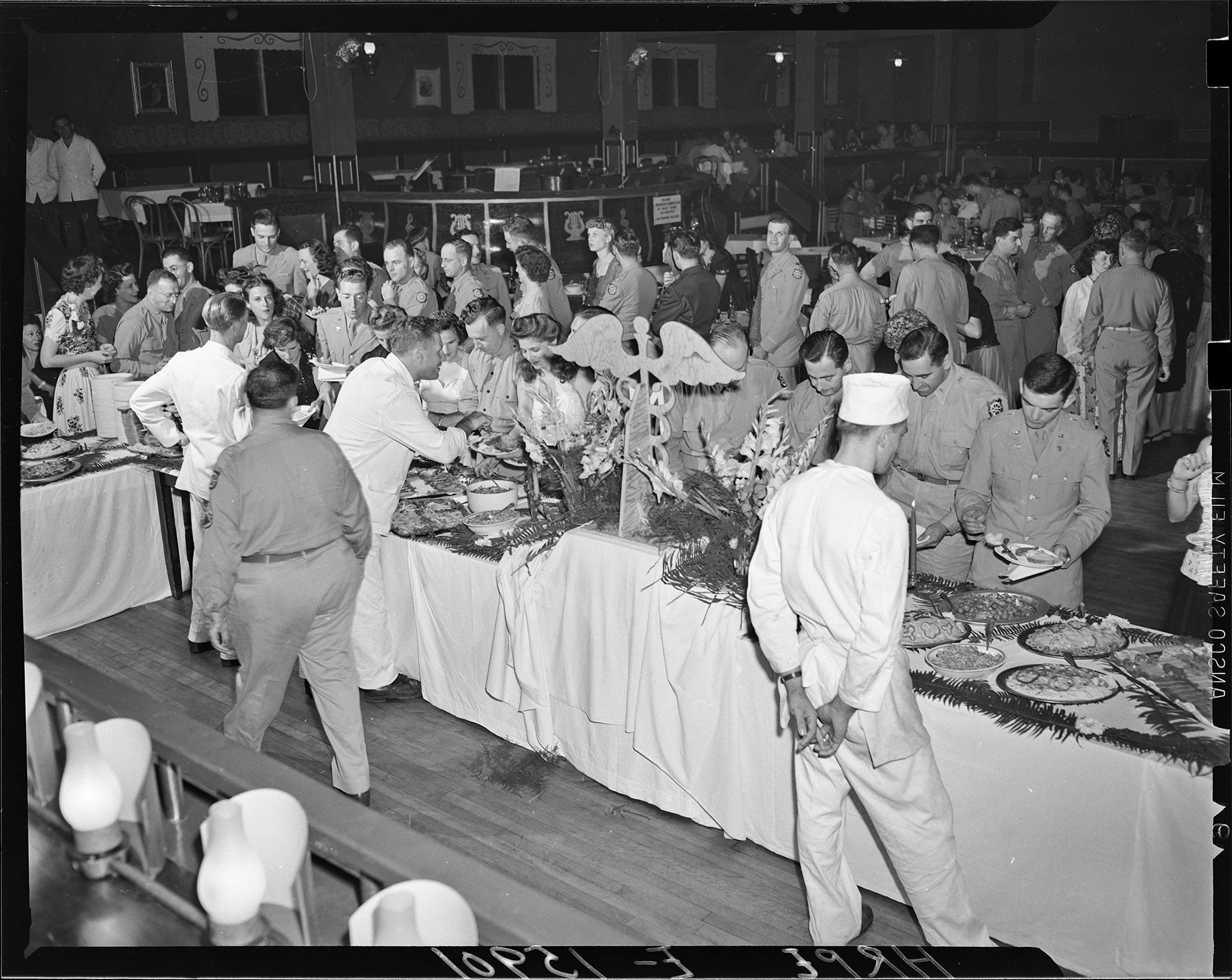 A buffet table filled with an assortment of food and a line of hungry guests waiting their turn.