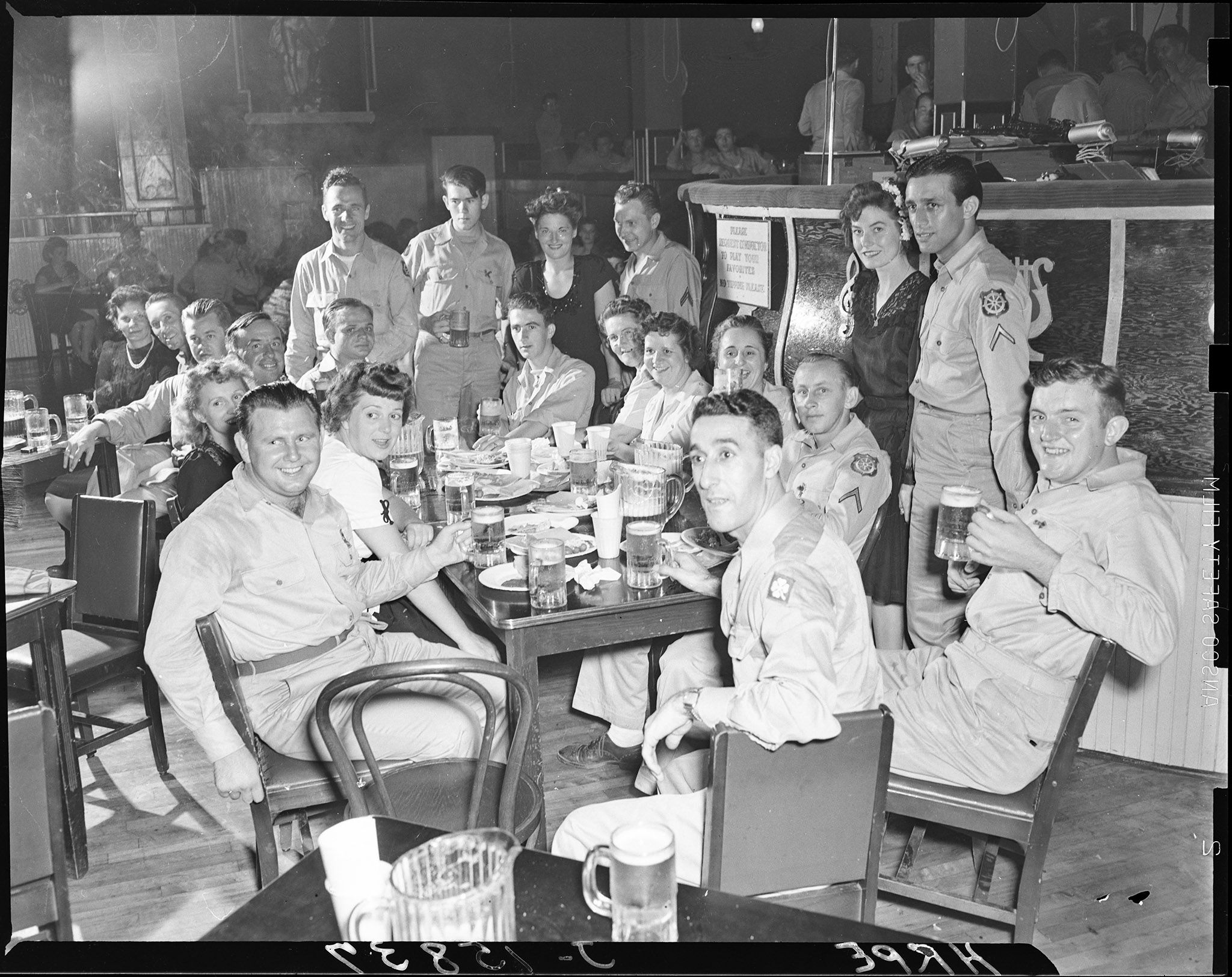 A group of nightclub-goers being surprised by something off-camera, beers clutched close.