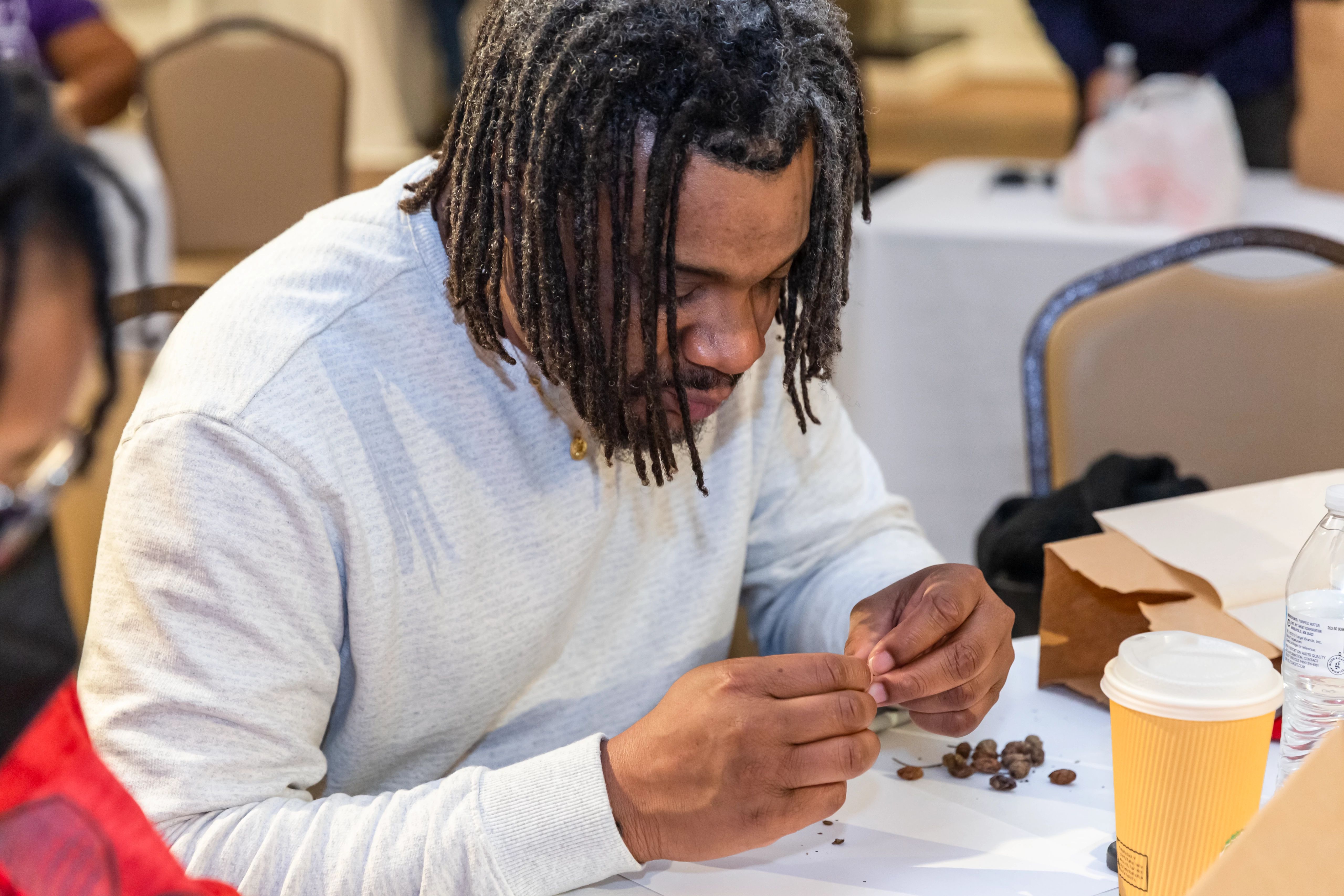 A teacher from Newport News Public High Schools working on preparing native seeds for planting in a B-WET teacher professional development session on native plants.