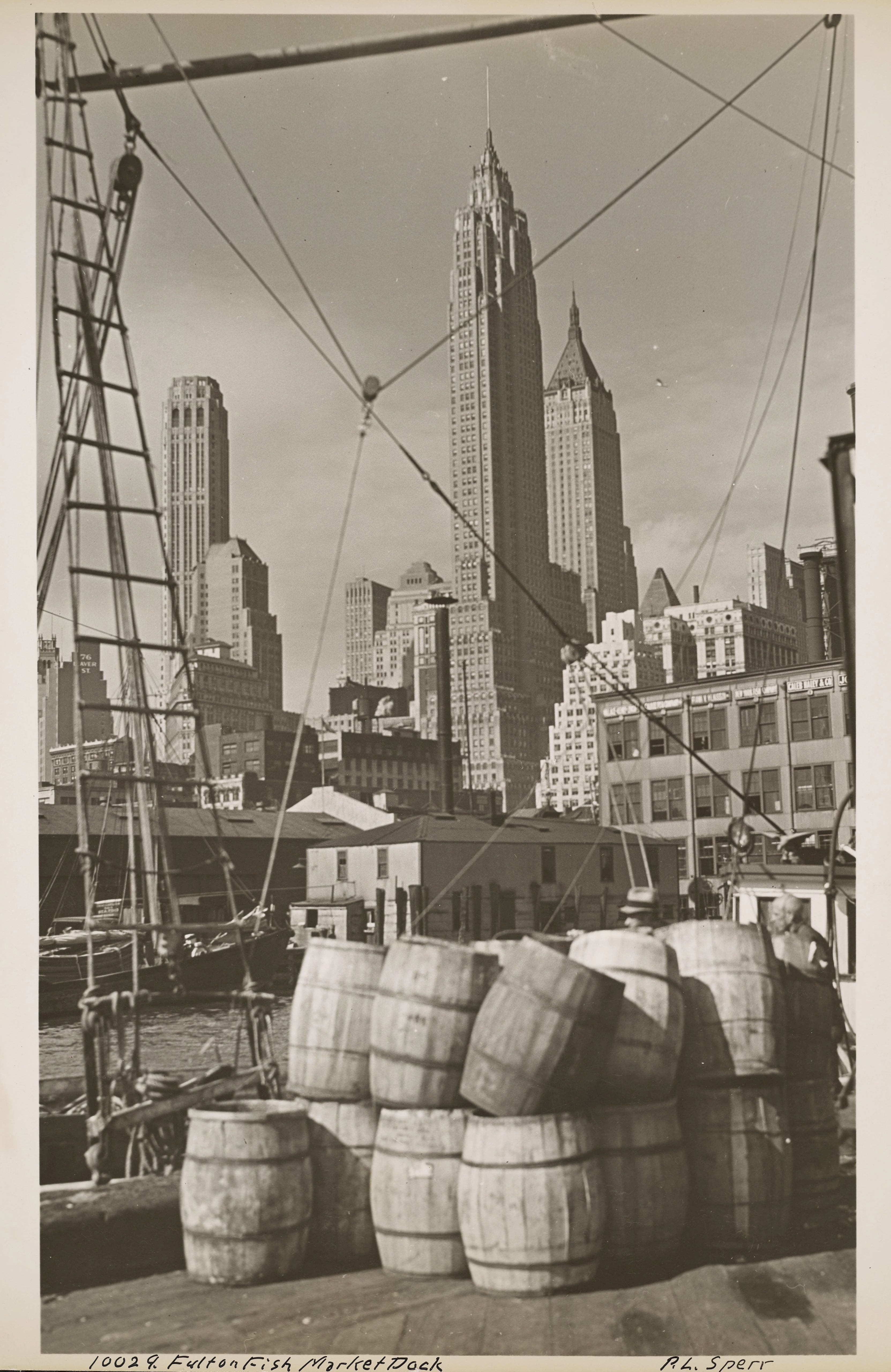 Barrels line the boardwalk, the New York skyline towers in the background.