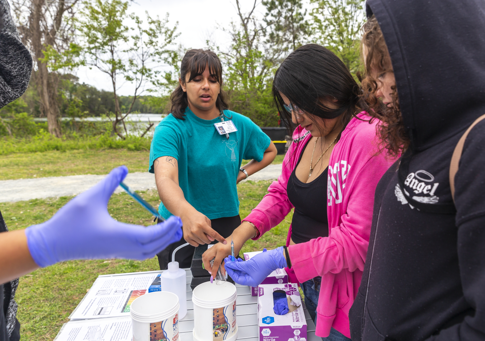 Science Educator, Claudia Moncada, assists students from Newport News Public High Schools with testing the water quality of Mariners’ Lake.