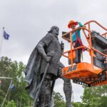 Image of Marimar on an orange lift in front of Leifr Eiriksson, Son of Iceland.