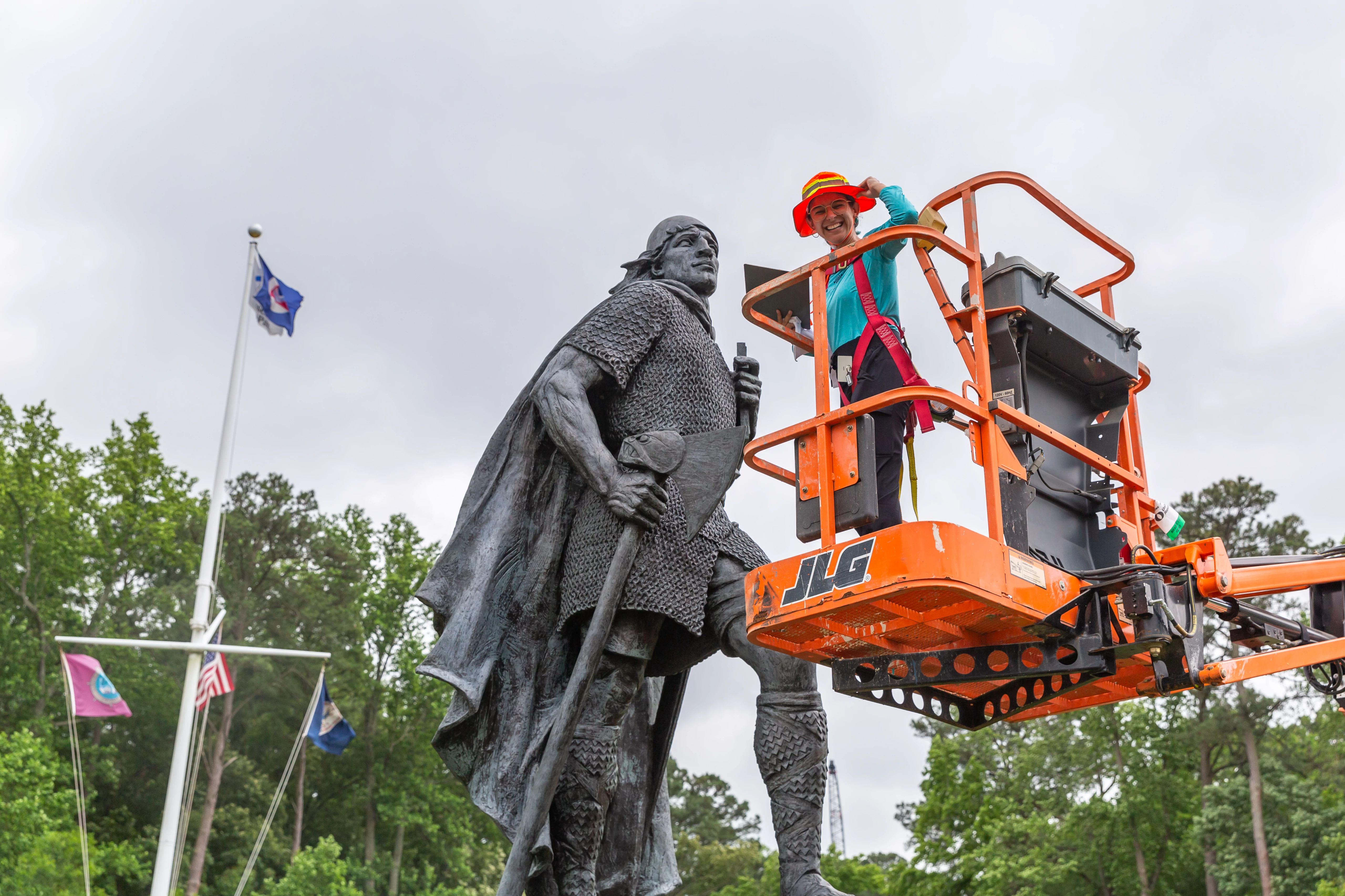 Image of Marimar on an orange lift in front of Leifr Eiriksson, Son of Iceland.