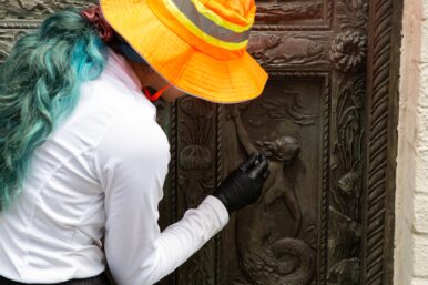Image of Marimar cleaning details on one of the bronze doors.