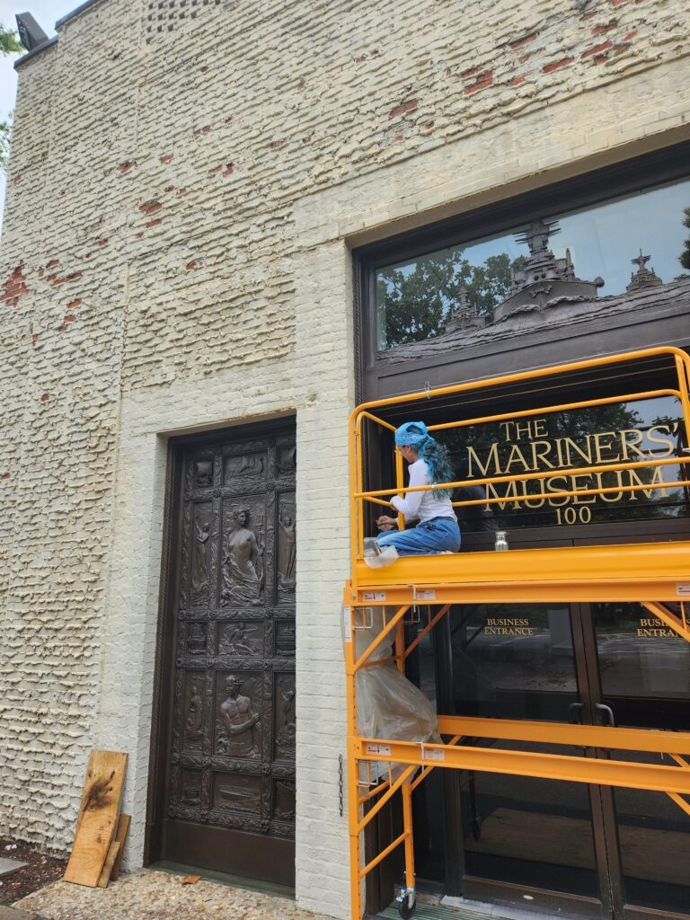 Image of Intern Marimar on a scaffold buffing.
