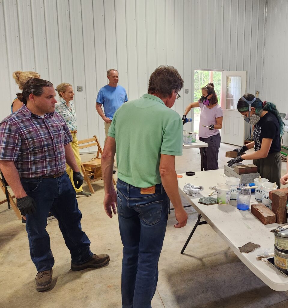 Image of participants of the Metal and Patina Workshop with Andrew Baxter working on patinas.