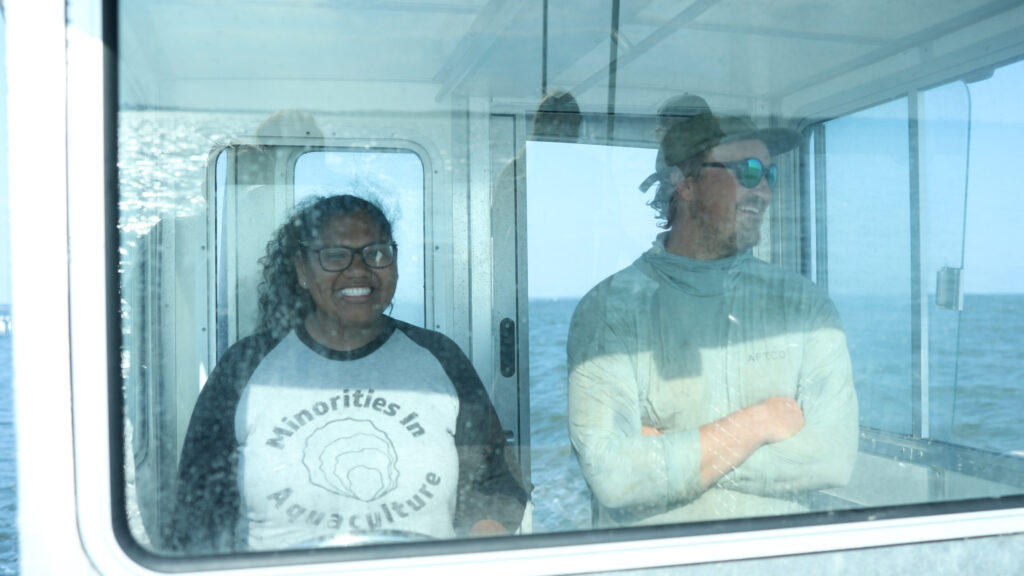 Makayla Lloyd and Corey Harris stand in the pilothouse of the Matheson Oyster Co. boat.