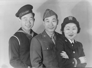 Two men and one woman pose for a picture, black and white. All wearing military uniforms.