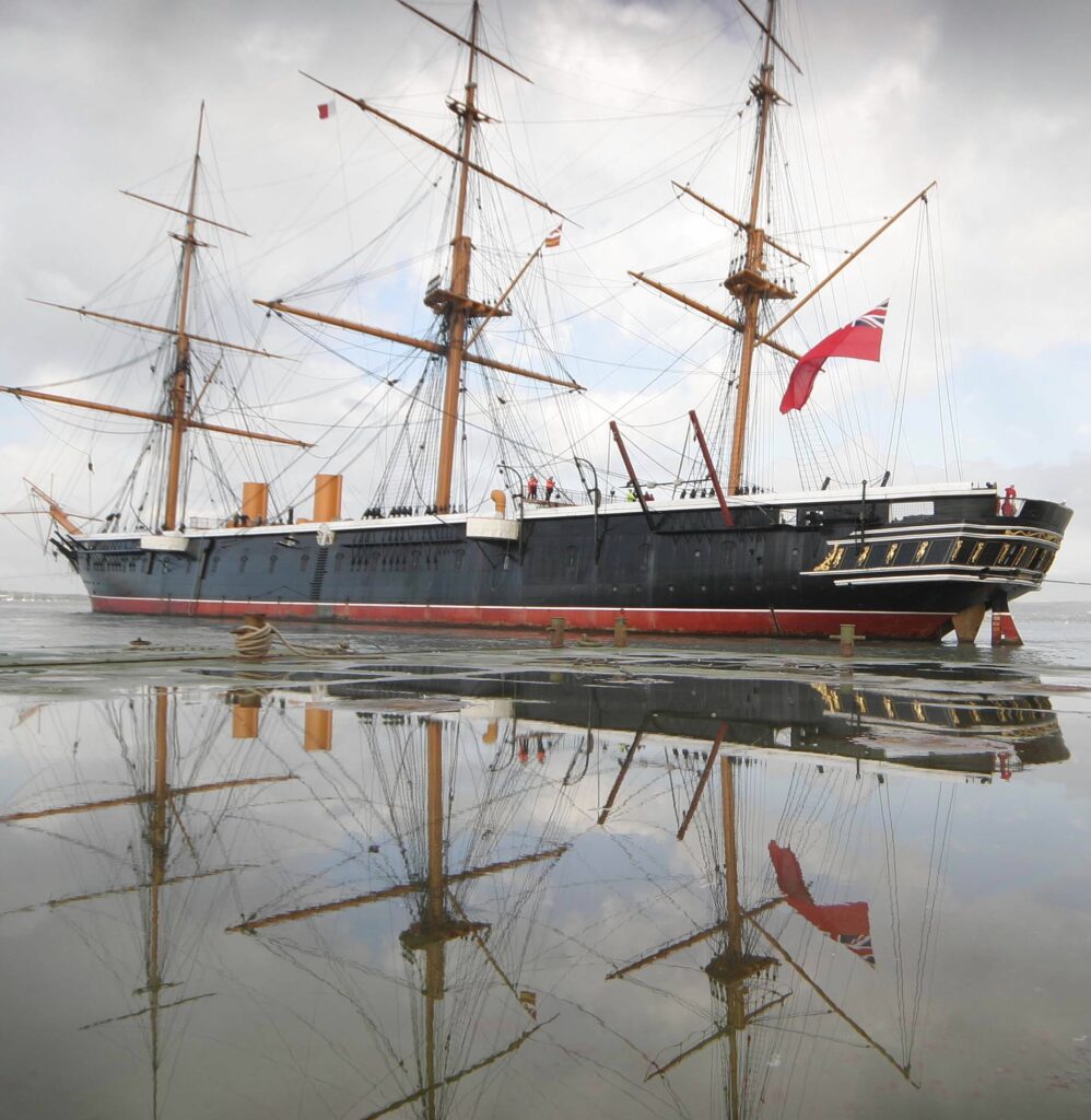Colored photo of the HMS Warrior battleship in the water.