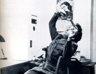 A woman in uniform observes a film strip.