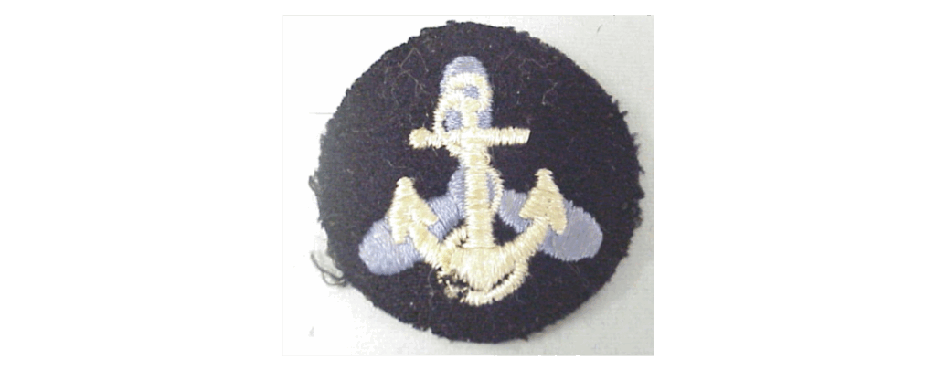 A blue button with a stitched image of an anchor in front of a propeller.