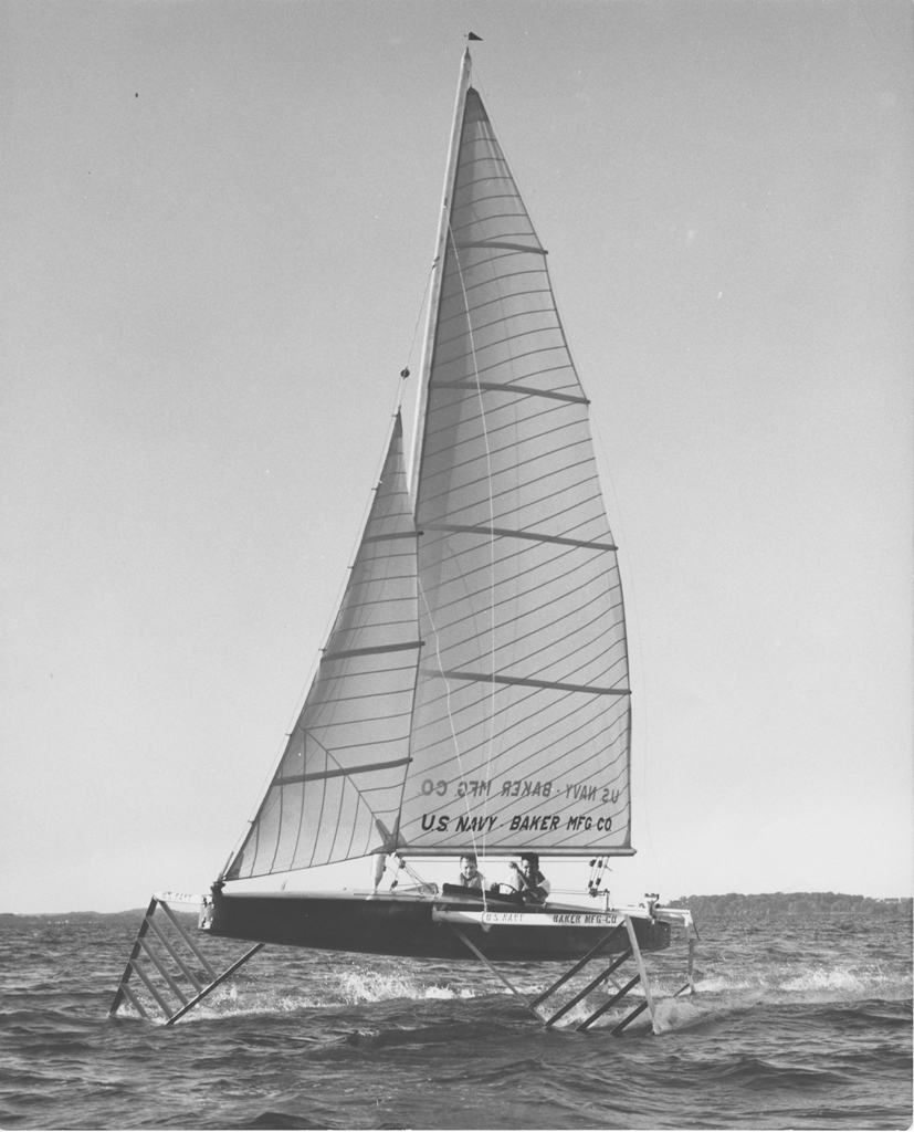 Black and white photograph of a hydrofoil-stabilized sailboats in the water.