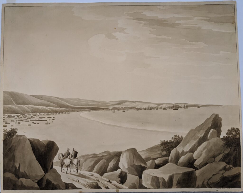 2 people ride horses next to the shoreline.