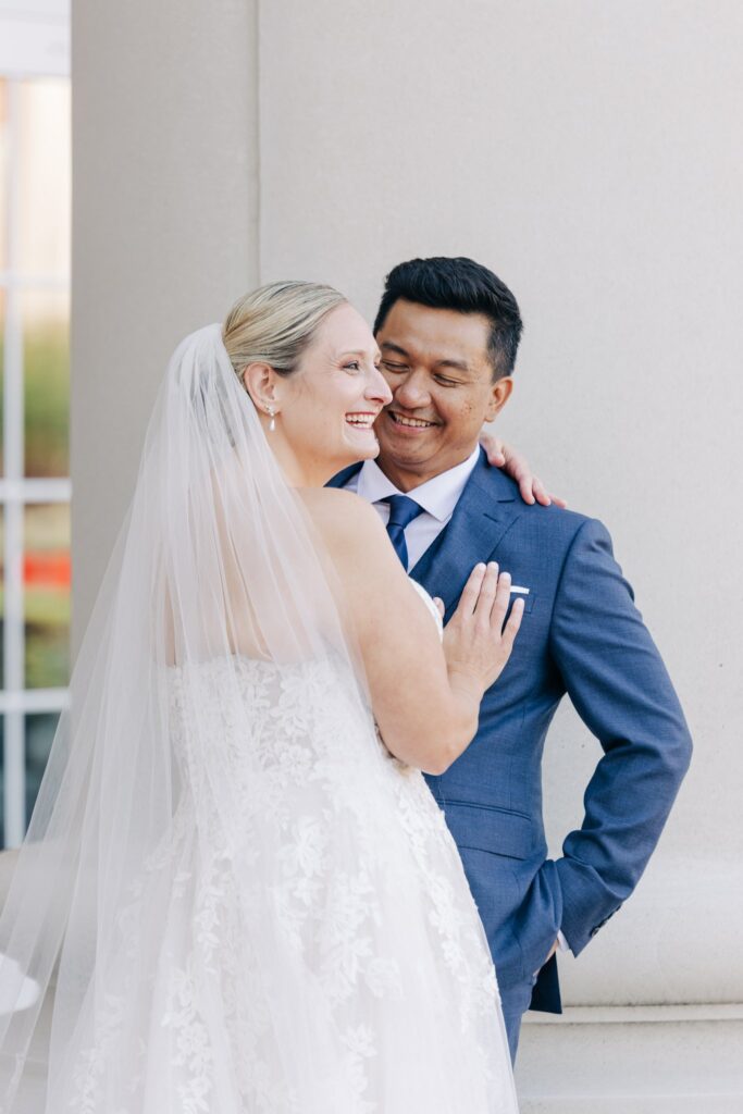 Bride and groom hugging and smiling.