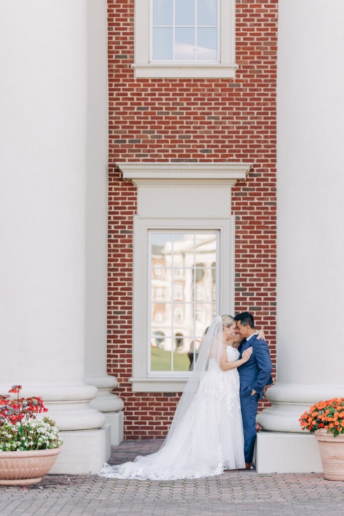Bride and groom posed in front of a brick building.
