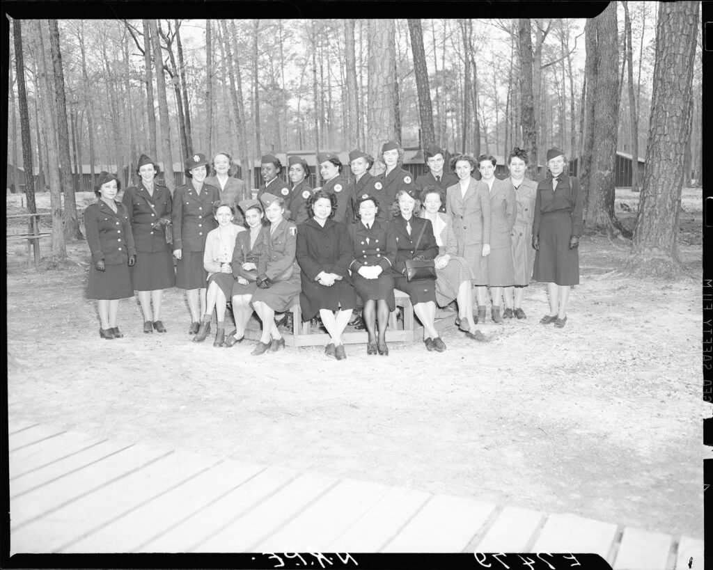 black and white photo of a group of women in uniform posing for the camera 