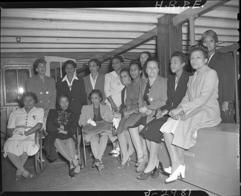 black and white photo of a group of women in formal clothing